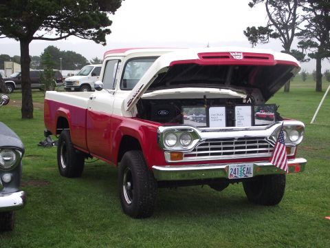 1993 Ford Bronco - A red and white 1959 Ford F-Series pickup truck is displayed with its hood open, informational signs and an American flag.