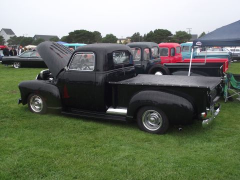 1993 Ford Bronco - Several classic trucks and cars are parked on a grassy field under an overcast sky.