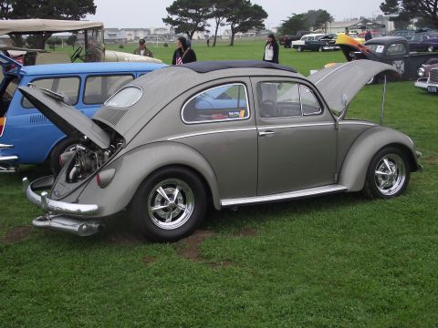 1993 Ford Bronco - A gray Volkswagen Beetle is displayed with its engine compartment and trunk open at an outdoor car show.