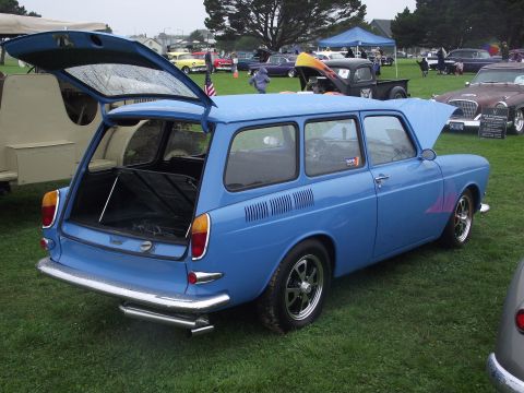 1993 Ford Bronco - A blue station wagon is displayed with its trunk and hood open at an outdoor event, surrounded by other vehicles.