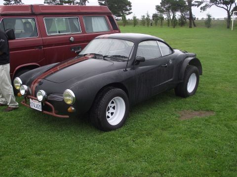1993 Ford Bronco - Modified Volkswagen Karmann Ghia with custom flares and stripes sits on grass next to a van.