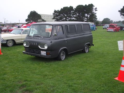 1993 Ford Bronco - A dark gray van is parked on a grassy field at an outdoor car show, with other vehicles visible in the background.