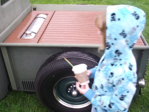 1993 Ford Bronco - A child stands by a truck bed, holding a drink, with a spare tire visible.
