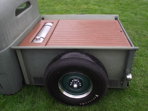 1993 Ford Bronco - Customized pickup truck bed features wood slat flooring and an exposed fuel tank, with a spare tire mounted externally.