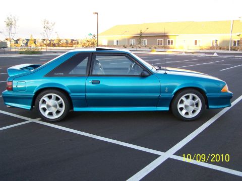 1995 Ford Bronco - Side view of a teal coupe with a rear spoiler.