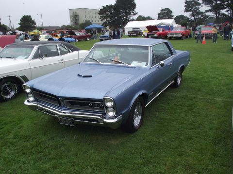 1993 Ford Bronco - A classic blue Pontiac GTO is displayed at an outdoor event with other vehicles present.