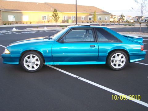 1995 Ford Bronco - This teal Ford Mustang coupe has a distinctive body style and a rear spoiler.