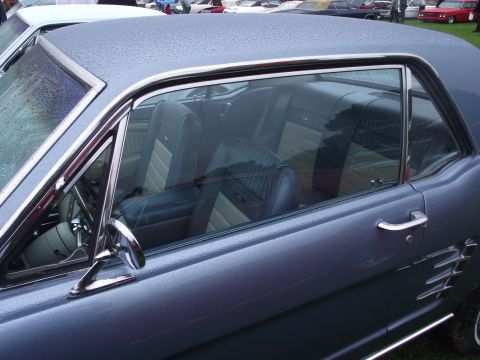 1993 Ford Bronco - The interior of a 1965 Ford Mustang coupe, seen from the side with the doors closed.