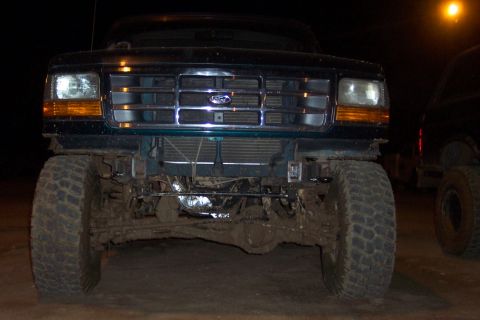 1995 Ford Bronco - Mud-covered 1995 Ford Bronco front end, with another vehicle in the background.