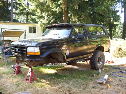 1995 Ford Bronco - This black Ford Bronco is on jack stands, undergoing maintenance or modification.