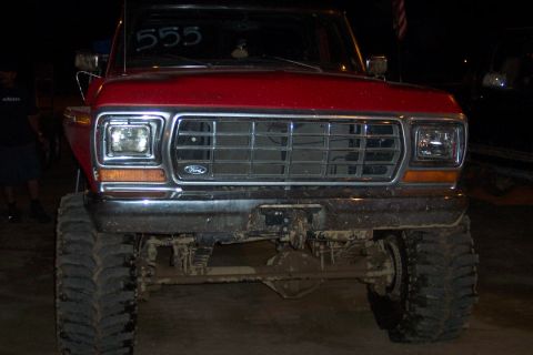 1995 Ford Bronco - This lifted Ford F-Series truck features a prominent chrome grille and oversized tires, with '555' marked on its windshield.