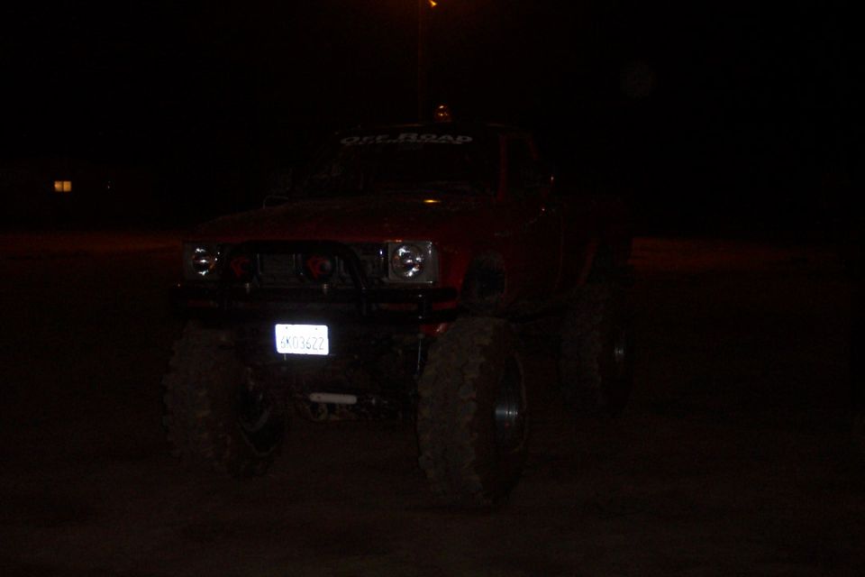 Red lifted truck with off-road banner and custom grille