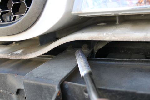 2003 Ford Crown Victoria - Close-up view of a push bar mounting bracket, showing bolts and part of the vehicle's front end.