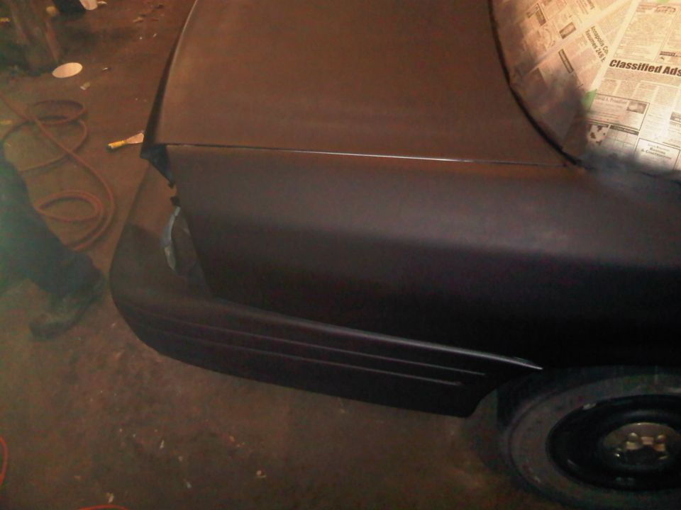 Dark sedan rear quarter panel, primer finish