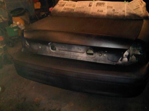 2003 Ford Crown Victoria - The rear of a 2003 Ford Crown Victoria is shown, with the trunk lid covered in newspaper for protection during a painting project.