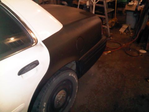2003 Ford Crown Victoria - The rear quarter panel of a two-tone car, likely a 2003 Ford Crown Victoria, is shown in this side view.