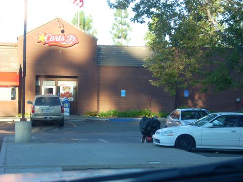 1989 Ford Bronco - A view of a Carl's Jr. restaurant with several vehicles in the parking lot.
