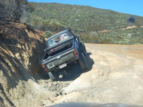 1989 Ford Bronco - A Toyota pickup truck navigates a rocky off-road trail.