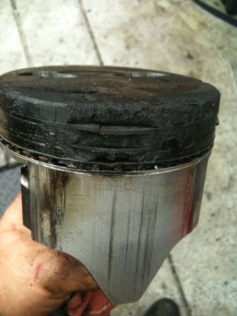 1990 Ford Bronco - This piston shows significant carbon buildup and wear, indicating potential engine issues.