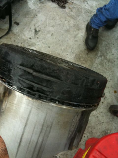 1990 Ford Bronco - A heavily worn piston shows significant carbon buildup on its crown.