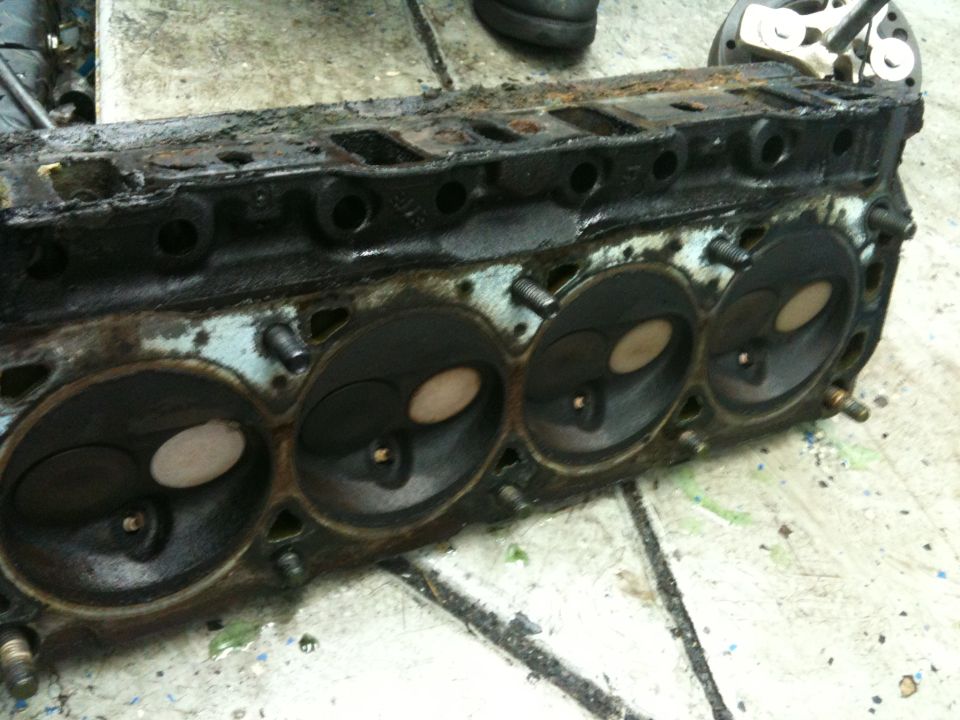 dirty engine cylinder head with four visible combustion chambers