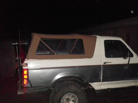 1991 Ford Bronco - Side view of a 1991 Ford Bronco a brown soft top and two-tone paint.