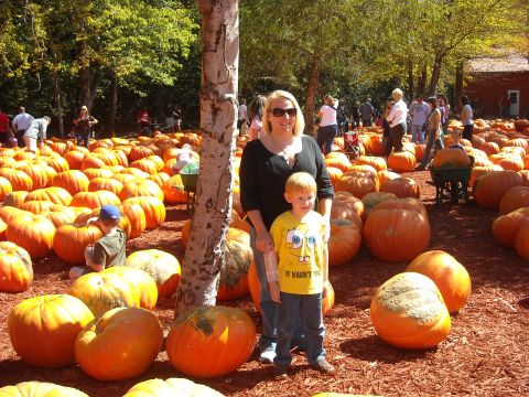 1979 Ford F-150 - A woman and a child are at a pumpkin patch with many pumpkins and people in the background.