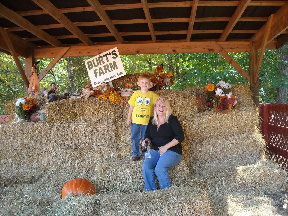 Mom and son posing on hay bales at Burt's Farm in Dawsonville, GA