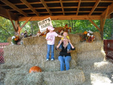 1979 Ford F-150 - A family enjoys a fall day at Burt's Farm, posing for a photo amidst hay bales and seasonal decorations.