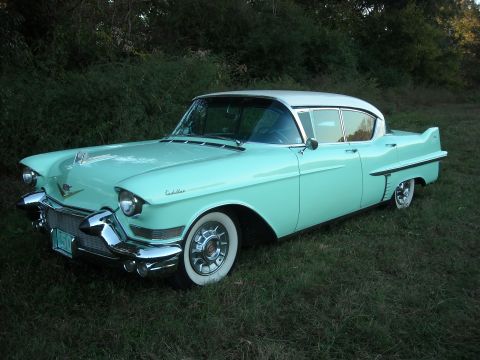 1979 Ford F-150 - Turquoise and white 1957 Cadillac Coupe de Ville seen outdoors in grassy area.