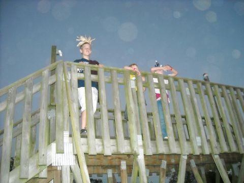 1979 Ford F-150 - Three children are visible on a wooden deck, one wearing a distinctive headdress, under a twilight sky.