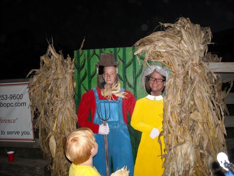 1979 Ford F-150 - A family enjoys a fall-themed photo opportunity with cutout characters and corn stalks.