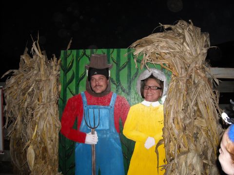1979 Ford F-150 - A photo booth with cutouts of a farmer and a woman, decorated with corn stalks.