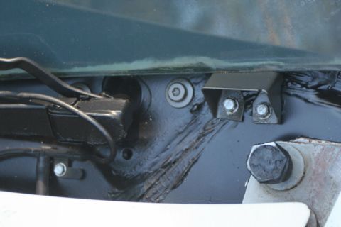 1976 Ford Ranchero - Close-up view of a vehicle's cowl mounting bracket, showing bolts and wiring harness details.