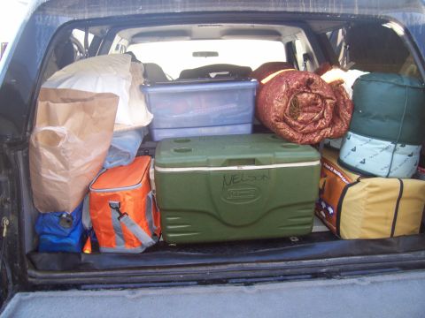 1994 Ford Bronco - Vehicle cargo area filled with camping supplies, including coolers and sleeping bags.