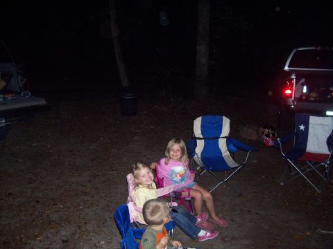 1994 Ford Bronco - Children relax in camping chairs at night, with a pickup truck parked nearby.