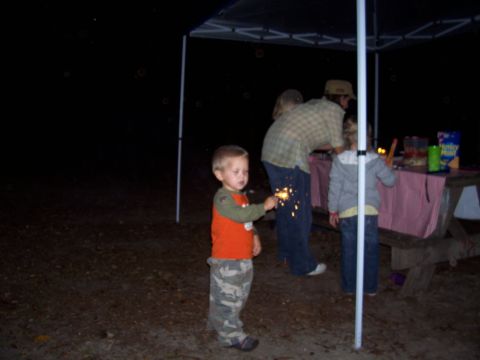 1994 Ford Bronco - A child holds a sparkler while a family gathers around a picnic table at night.