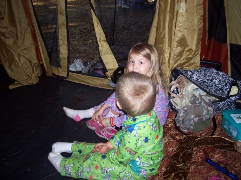 1994 Ford Bronco - Two young children are sitting inside a tent, dressed in pajamas and surrounded by camping gear.