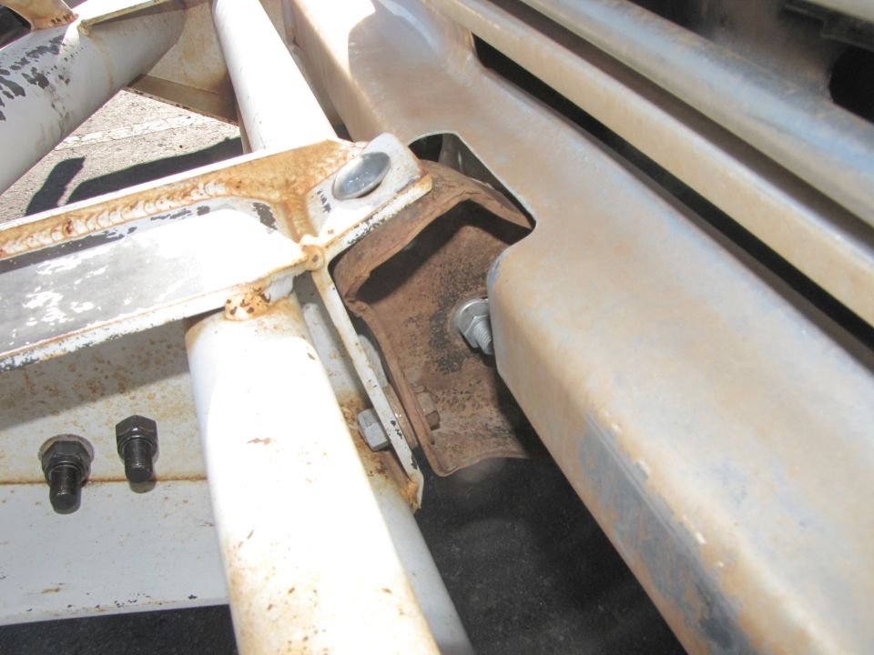 close-up of rusty metal brackets and bolts on a vehicle frame