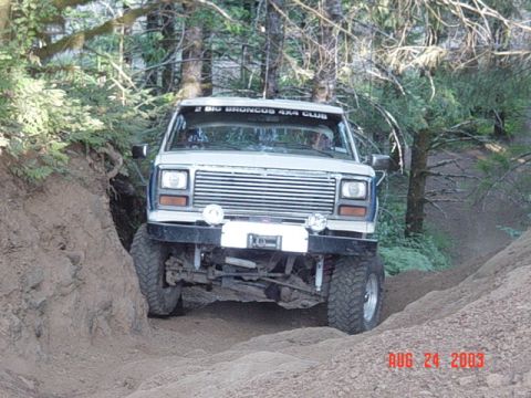 1989 Ford Bronco - A white 1989 Ford Bronco navigates a challenging off-road trail, as indicated by the date stamp on the photo.