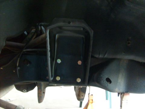 1986 Ford Bronco - This image shows a close-up view of a vehicle's frame and a bolted metal bracket, likely part of the suspension or chassis.