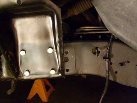 1986 Ford Bronco - Vehicle frame section supported by an orange jack stand, with Supermotors.net branding in the corner.