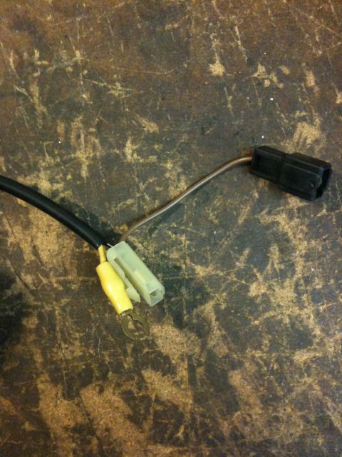 Suzuki Samurai - A close-up view of a wiring harness connector with yellow and black components against a textured background.