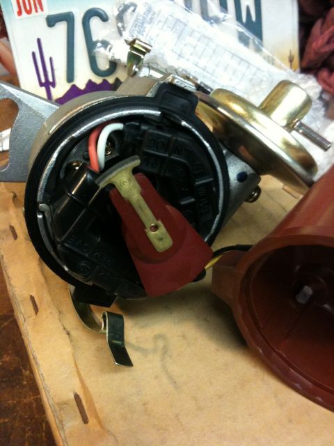 Suzuki Samurai - Close-up of a distributor cap and rotor assembly, with a license plate reading '76' visible in the background.