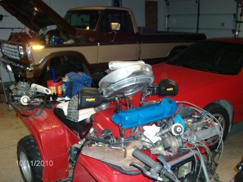1979 Ford F-150 - A 1975 Ford F-150 truck is undergoing maintenance in a garage, with a red car also visible.