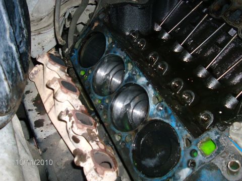 1979 Ford F-150 - Close-up view of an engine block, showing pistons and an exhaust manifold. The condition suggests internal engine work.