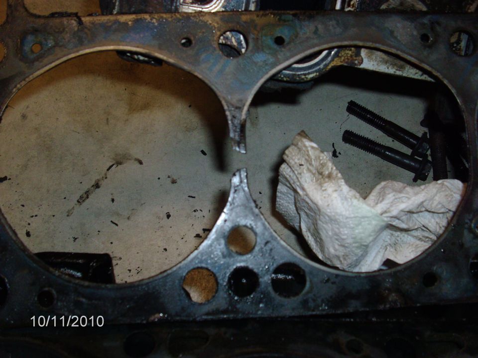 Engine block deck with two cylinder bores and head bolts during teardown