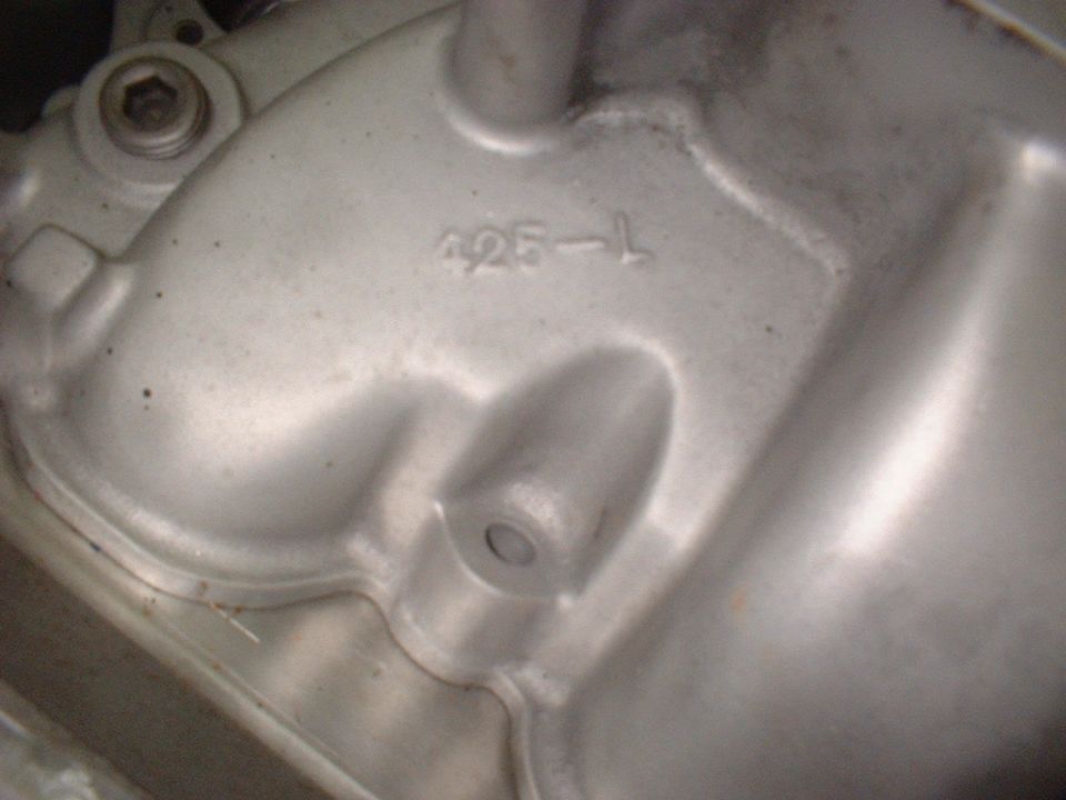 Close-up of a silver metal casting with '425-L' stamped on it