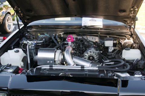 2006 Cadillac STS - Engine bay features a turbocharger and custom intercooler piping, with a fuzzy toy on the intake.