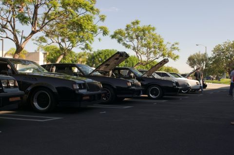 2006 Cadillac STS - A line of black Buick Grand Nationals are parked side-by-side with their hoods open under a sunny sky.